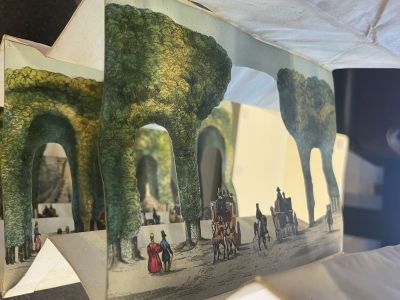 A view of one of the tunnel book’s pages with detailed cutouts. These cutouts give the book a feeling of depth by enabling the viewer to look at layers of images.